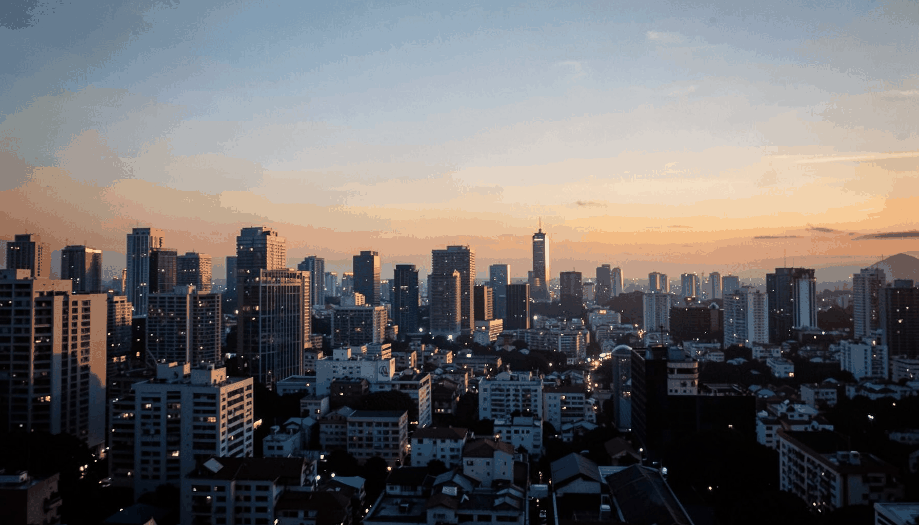 Warm evening light over a city skyline with soft amber and navy tones, romantic and reflective mood
