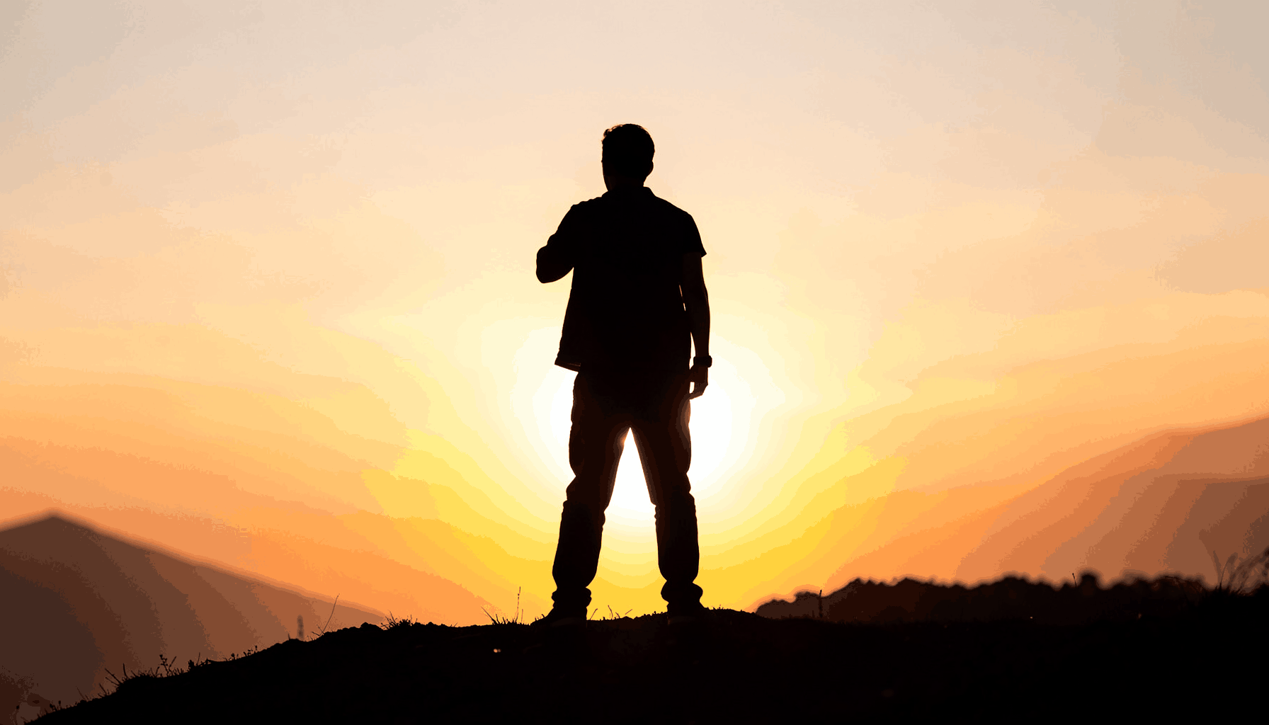 A motivational silhouette of a person standing confidently at sunrise on a hilltop, warm golden and amber tones against a soft sky